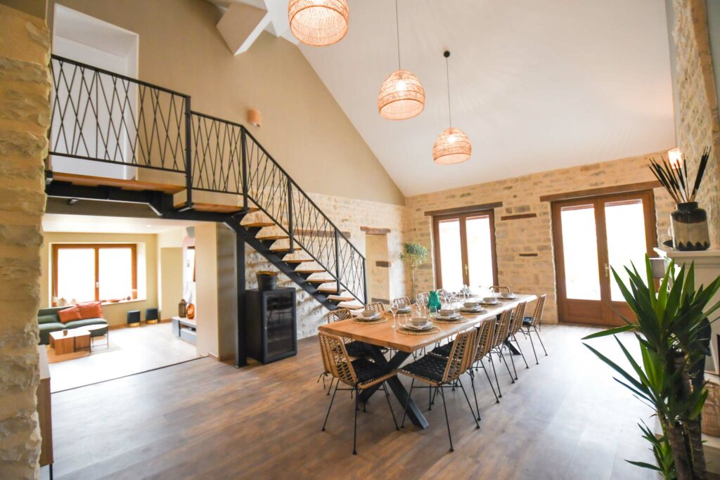 magnifique séjour en pierre avec table en bois pour 12 convives et escalier design