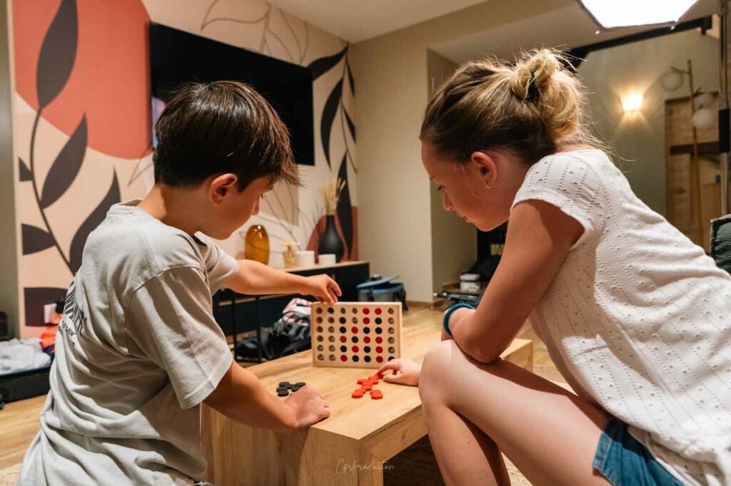 deux enfants qui jouent au jeux de société dans le salon